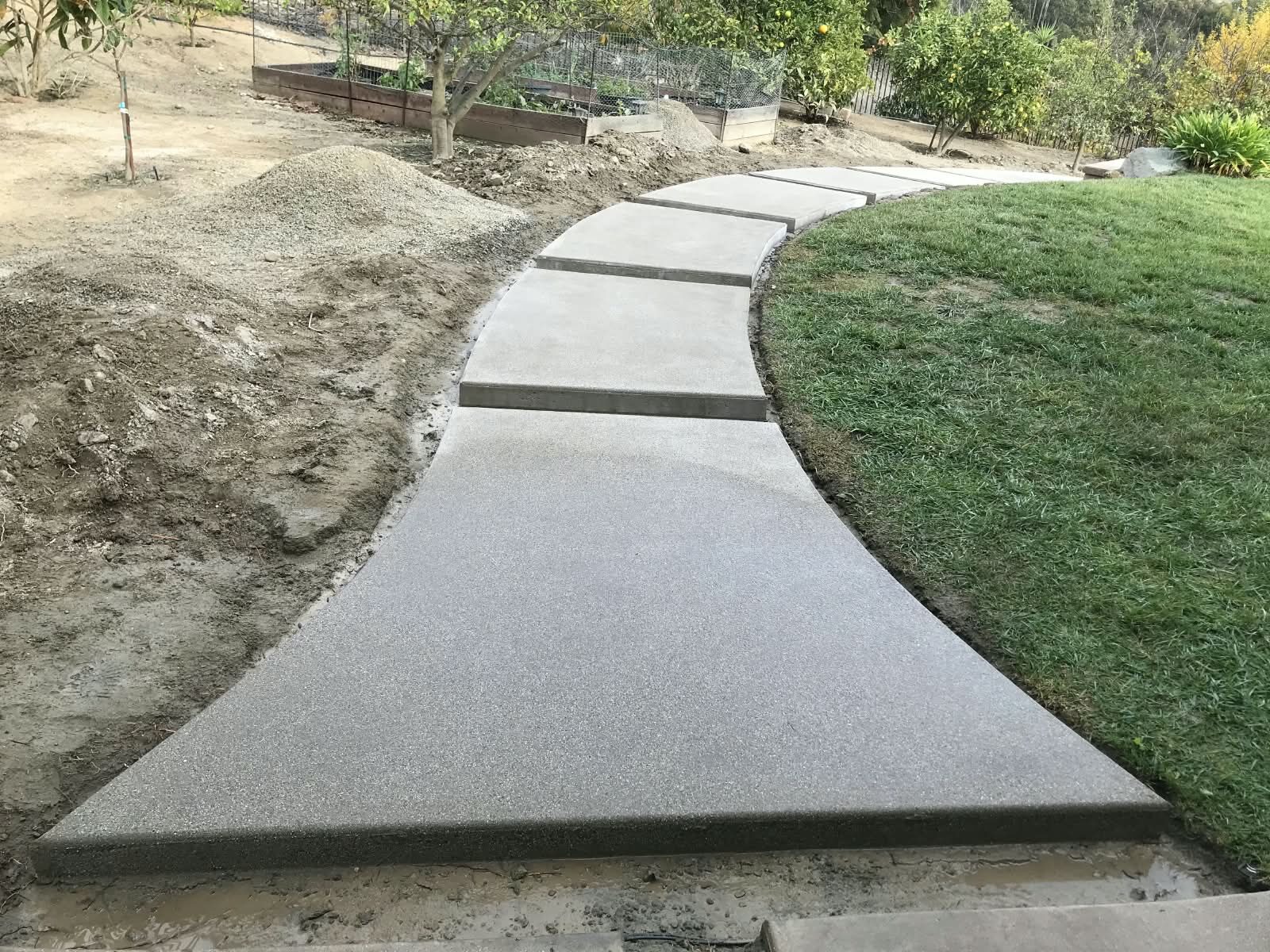 Curved concrete walkway next to the lawn